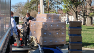 loading pallet of boxes onto truck outside the library